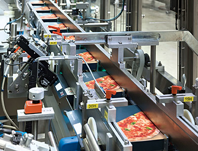 Der Pizzakartonierer HK P3 verarbeitet bis zu 160 Kartons pro Minute. Prinzipiell sind auf dieser Anlage bis zu vier Pizzen pro Schachtel möglich.