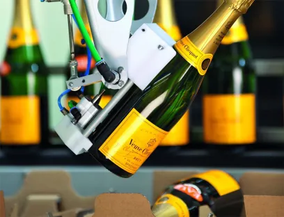 Robotergestützte Verpackungssysteme: Roboter handeln wertvolle Champagner-Flaschen, ohne die Etiketten zu berühren