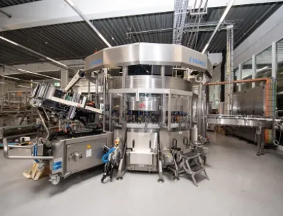 Ein Servomotor dreht die Flaschen, Linearmotoren drücken die Folie mithilfe von Schwämmen an die Behälter an