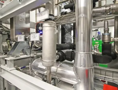 Detailansicht der Absorptionskältemaschine, im Hintergrund das Blockheizkraftwerk, Bild: Geiger Energietechnik Detailansicht der Absorptionskältemaschine